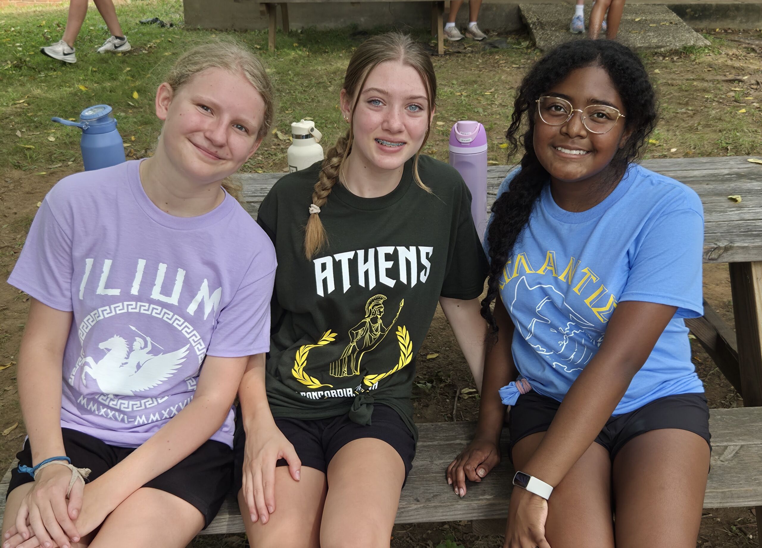 Three students in Ilium, Athens and Atlantis house shirts at the Upper Campus retreat